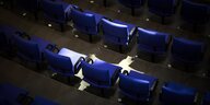 Eine leere Stuhlreihe im Bundestag wird von Sonnenlicht beschienen