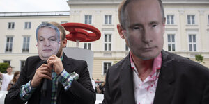 Zwei Demonstranten mit Masken von Orban und Putin