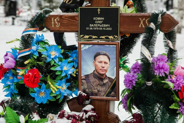 Das mit Blumen geschmückte Grab eines getöteten Soldaten mit einem Porträt, das ihn in Uniform zeigt Das mit Blumen geschmückte Grab eines getöteten Soldaten mit einem Porträt, das ihn in Uniform zeigt