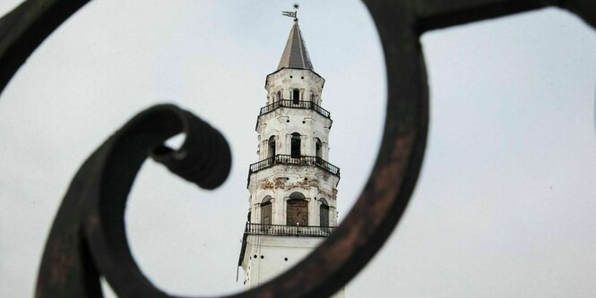 Ein weißer Turm durch ein Gitter fotografiert