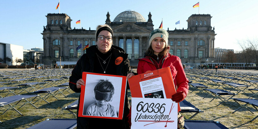 Zwei Frauen mit Protestschildern