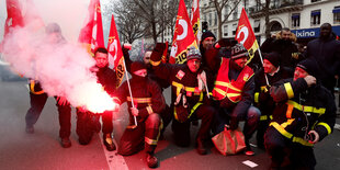 Feuerwehrleute demonstrieren mit Fahnen