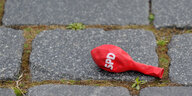 Nicht aufgepusteter SPD-Luftballon liegt auf dem Boden