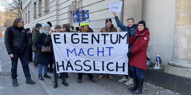 Eine Gruppe Menschen hält ein Transparent auf dem steht "Eigentum macht hässlich".