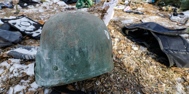 Ein Helm mit der Aufschrift Sanara liegt in den Trümmern