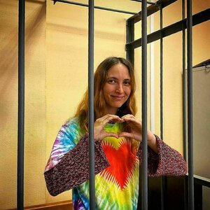 Alexandra Skotschilenko steht hinter Gittern und formt die Hände zu einem Herz Alexandra Skotschilenko steht hinter Gittern und formt die Hände zu einem Herz