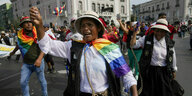Menschen in traditionell indigener Kleidung der Anden demonstrieren auf einer Straße