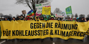"Gegen die Räumung, für Kohleausstieg und Klimagerechtigkeit" ist auf dem Transparent zu lesen, das von Demonstranten getragen wird