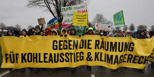 "Gegen die Räumung, für Kohleausstieg und Klimagerechtigkeit" ist auf dem Transparent zu lesen, das von Demonstranten getragen wird