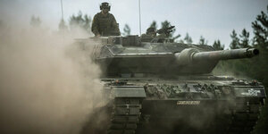 Ein Leopard-2-Panzer der Bundeswehr, der von der NATO Enhanced Forward Presence Battle Group (eFP-Bataillon) eingesetzt wird, fährt beim Besuch von Bundeskanzler Scholz durch das Camp Adrian Rohn