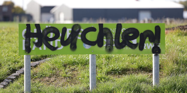 In der Nähe von Garzweiler II: Übersprühtes RWE Schild mit der Aufschrift "Grünes Band". Jetzt steht da "Heuchler"r