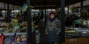 Eine Verkäuferin wartet auf einem Markt in Cherson auf Kundschaft