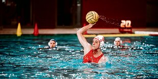 Maren Hinz hält kurz vor einem Wurf bei einem Wasserball-Spiel den Ball in der Hand.