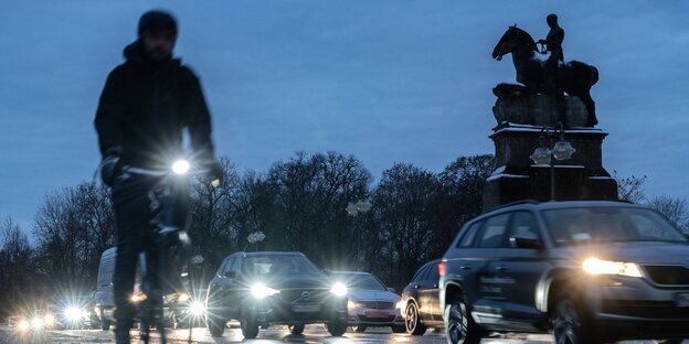 Ein Fahrradfahrer fährt bei einer Autokolonne vorbei