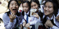 Vier Mädchen in Schuluniform und einer Tüte mit Snacks