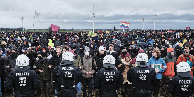 Viele Demonstranten stehen vor einer Polizeikette