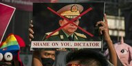 Demonstranten halten ein Schild hoch auf dem der Armee-Chef Min Aung Hlaing abgebildet ist - das Gesicht mit einem roten Kreuz durchgestrichen