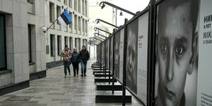 3 Personen gehen an der estnischen Botschaft in Moskau vorbei