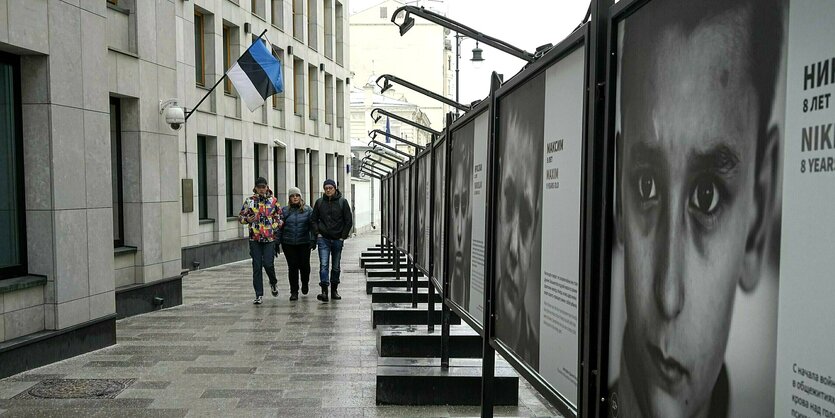 3 Personen gehen an der estnischen Botschaft in Moskau vorbei