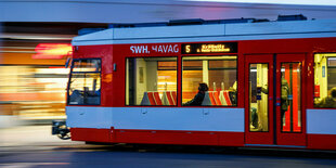 Fahrgäste sitzen im morgendlichen Berufsverkehr in einer fahrenden Straßenbahn