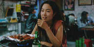 Freddie (Park Ji-min) sitzt mit einem Glas Soju in einem koreanischen Restaurant.