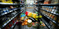 Verschiedene Lebensmittel liegen in einem Supermarkt in einem Einkaufswagen