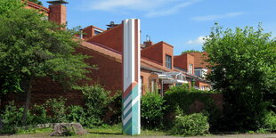 Blick auf eine Stele vor den Häusern der Siedlung Hamburg Bau in Poppenbüttel