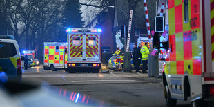 Fahrzeuge der Polizei und Feuerwehr und Rettungsdienste an einem Bahnübergang