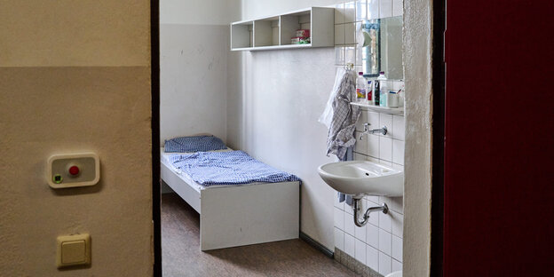 Eine Gefängniszelle mit Bett und Waschbecken