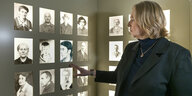 Bärbel Bas zeigt auf Schwarz-Weiß-Aufnahmen an einer Ausstellungswand, ihre Hand unter der aufnahme von Mary Pünjer
