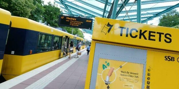 gelber Fahrkartenautomat mit der Aufschrift "Tickets" an einem Bahngleis