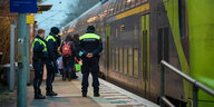 Sicherheitsleute der Deutschen Bahn stehen im Morgengrauen auf dem Bahnsteig im Bahnhof von Brokstedt