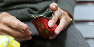 Eine Rentnerin hält ihren geöffneten Geldbeutel in ihrer Hand