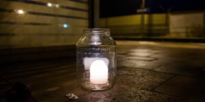 Eine Kerze in einem Glas steht auf dem Bahnsteig in Brokstedt