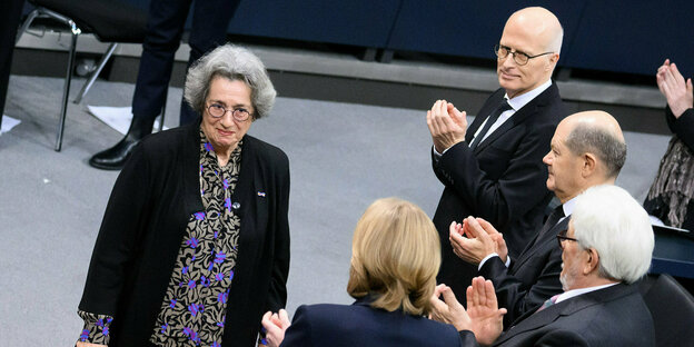 Rozette Kats geht nach ihrer Rede im Deutschen Bundestag an klatschenden Vertretern der Bundesregierung vorbei