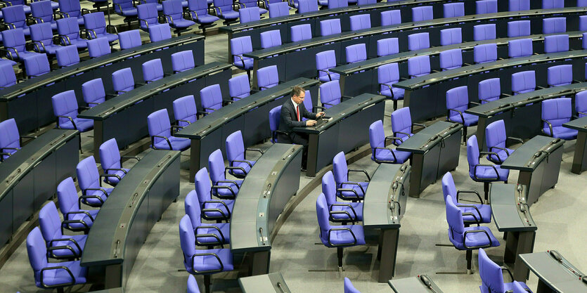 Ein Abgeordneter sitzt im leeren Bundestag