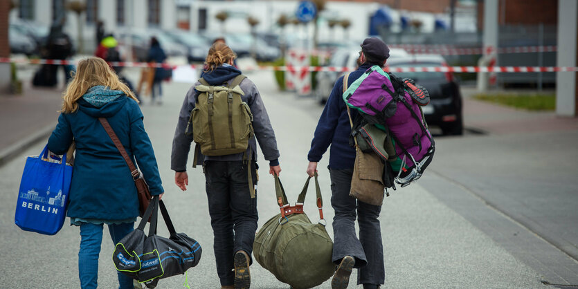 Eltern tragen mit ihrem Sohn schweres Gepäck