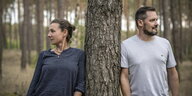 Autorin Juli Zeh und Autor Simon Urban lehnen sich von verschiedenen Seiten gegen einen Baumstamm