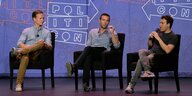 Tommy Vietor, Jon Favreau und Jon Lovett sitzen auf sschwarzen Sesseln vor eiem lila Hintergrund