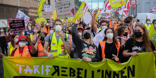 Menschen auf einer Demonstration hinter einem Transparent