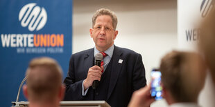 Hans-Georg Maaßen spricht vor einem Banner der Werteunion in ein Mikrofon