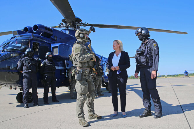 Bundesinnnenministerin Faeser mit Polizisten einer GSG-9 Einheit draußen in der Sonne