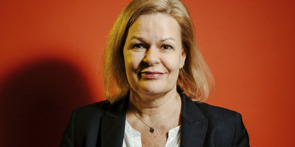 Bundesinnenministerin Faeser im Porträt vor SPD-rotem Hintergrund