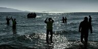Mitglieder einer Hilfsorganisation empfangen Geflüchtete an der griechischen Küste