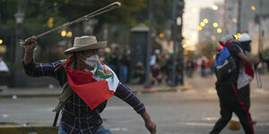 Ein regierungskritischer Demonstrant schwingt eine Schleuder bei Zusammenstößen mit der Polizei in Lima, Peru.