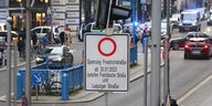 Eine Tafel weist darauf hin: Die Friedrichstraße in Berlin-Mitte soll ab 30.1.23 wieder für Autos geschlossen und zur Fußgängerzone