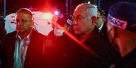 Zwei Männer, Ben-Gvir und Netanjahu, stehen bei Nacht zusammen, rotes Scheinwerferlicht trennt die beiden