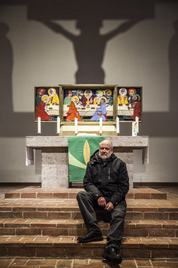 Ein Mann sitzt auf den Stufen vor einem Triptychon-Altarbild, ein Schatten des Gekreuzigten auf der Wand