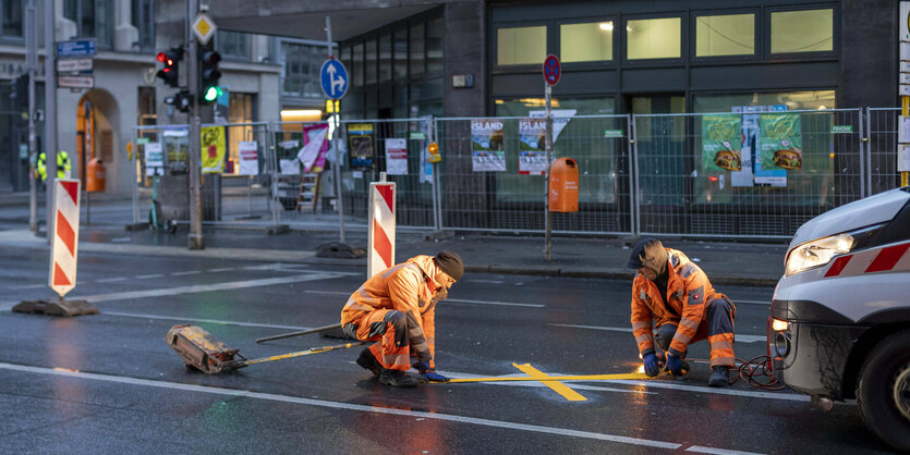 Arbeiter kleben Markierungen auf die Friedrichstraße