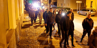 Menschen gehen nachts über eine Straße